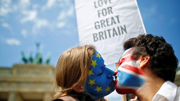 101117085_Two-activists-with-the-EU-flag-and-Union-Jack-painted-on-their-faces-kiss-each-other-in-fr-large